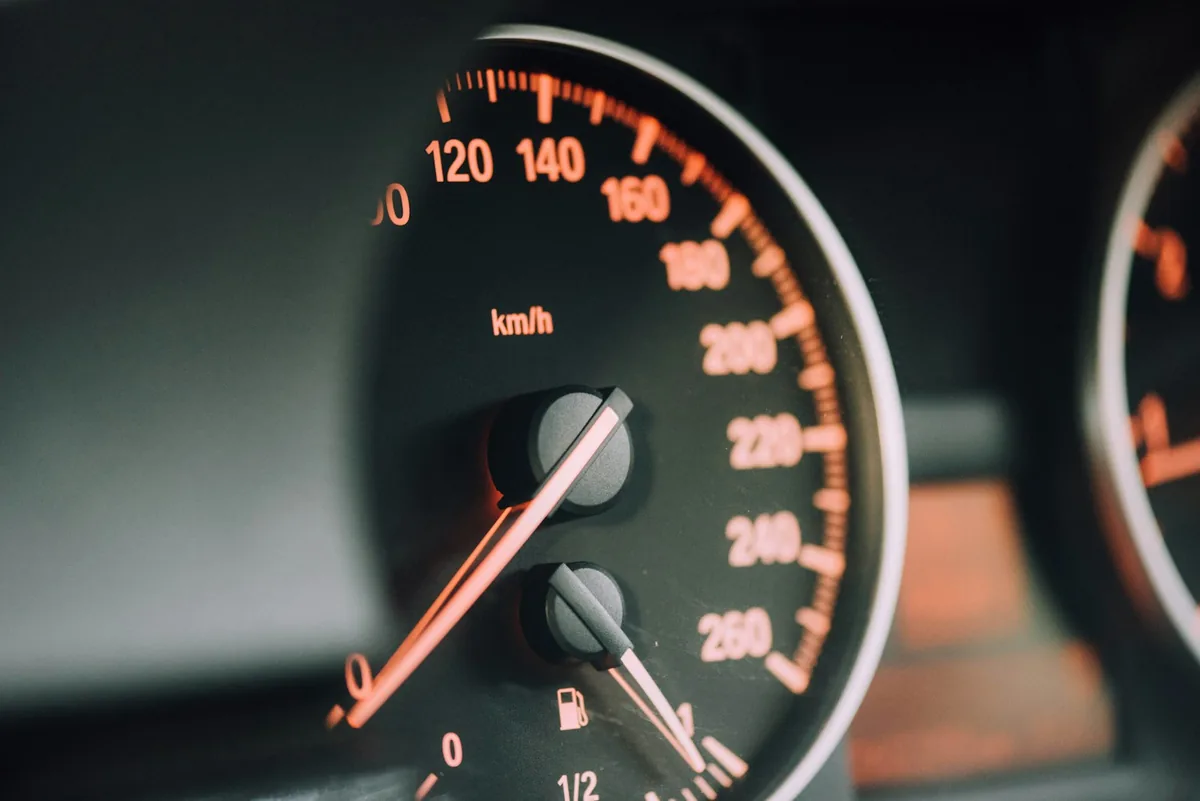 A car dashboard gauge cluster with warning lights