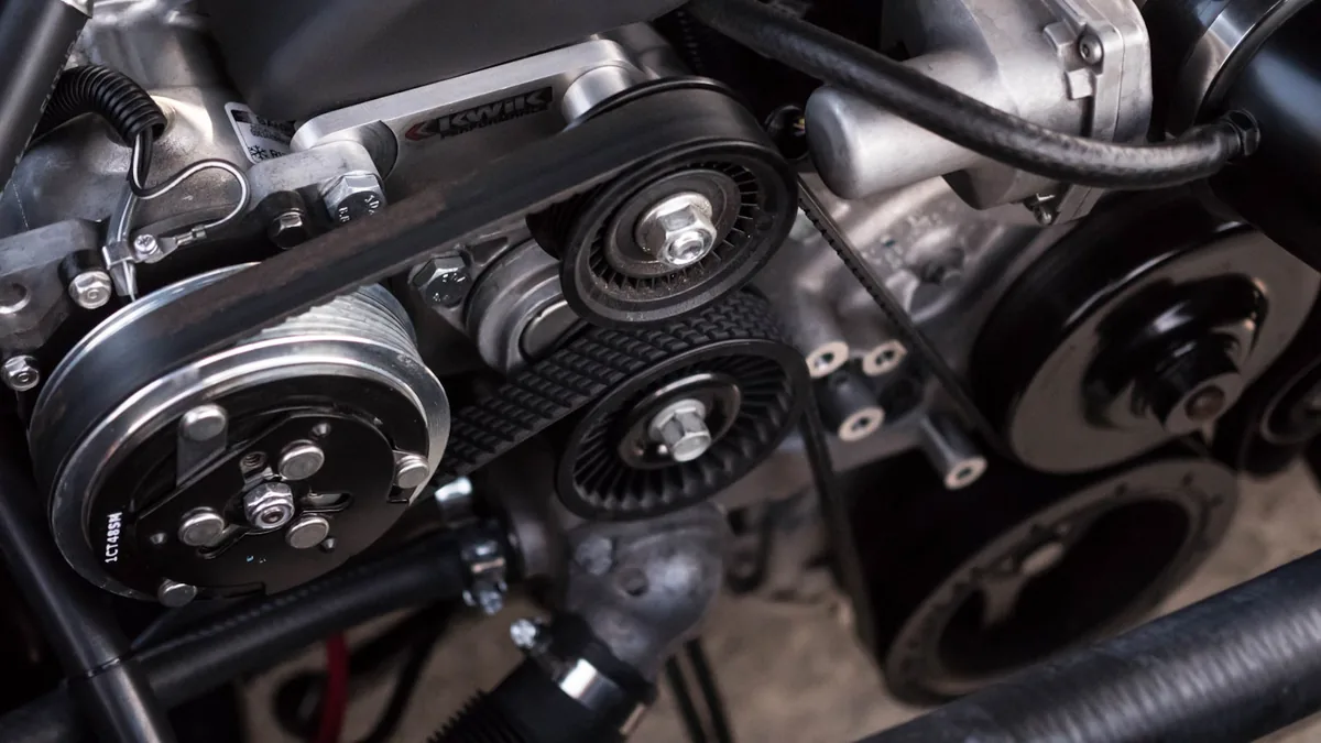Close-up of a car engine block showing the alternator and starter area